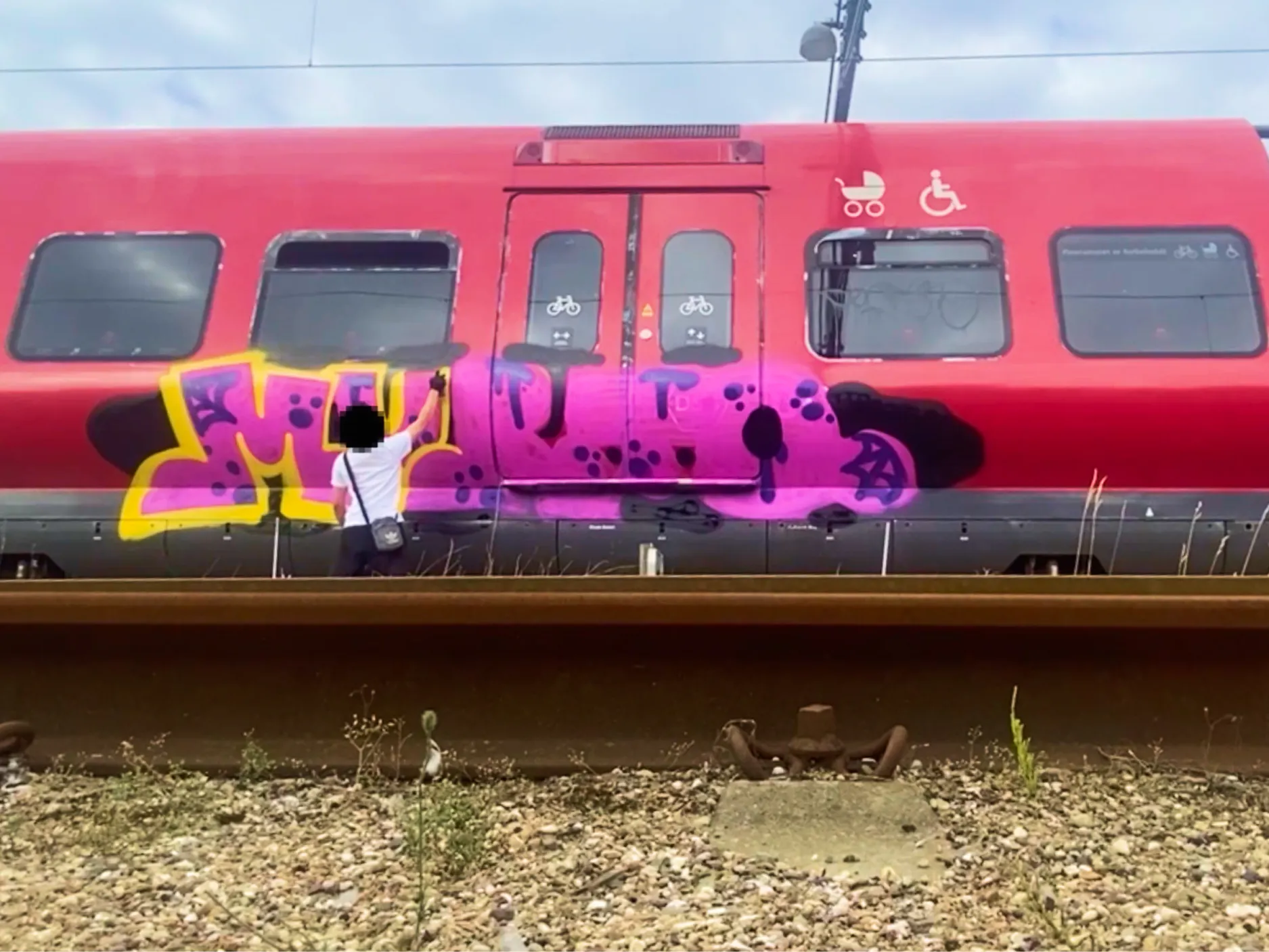 Cenzuriran moški, ki grafitira vlak